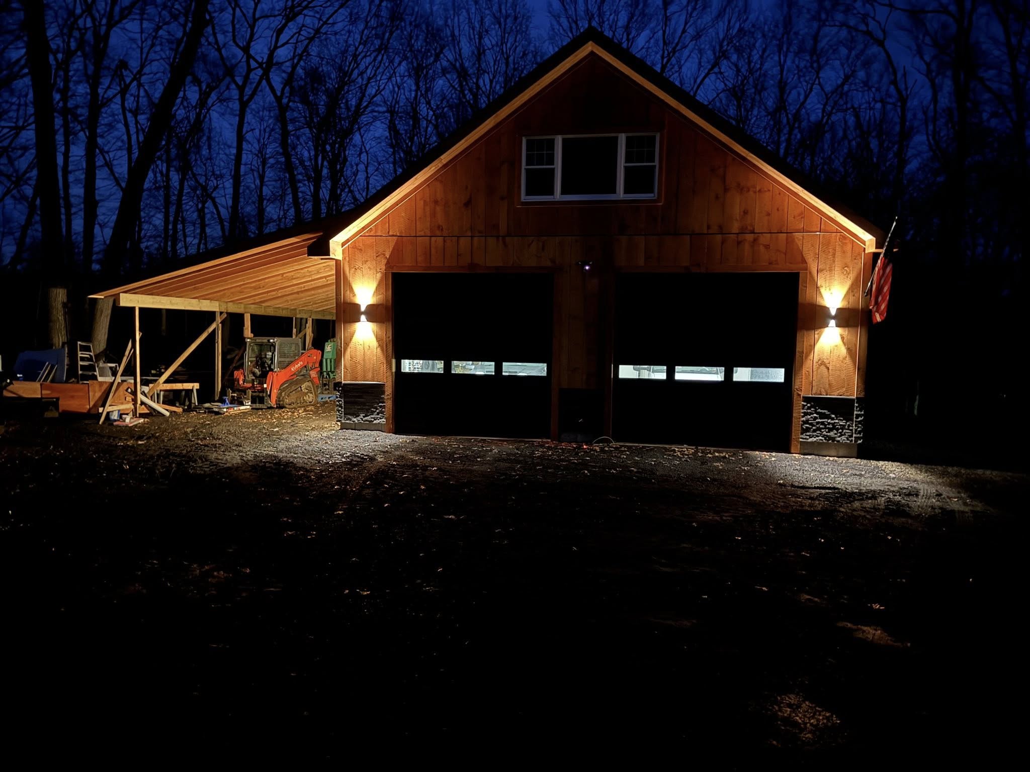 Detached Garage and workspace built in Connecticut Custom detached garage with dual bays and side workshop built by Lagace Construction in Connecticut, illuminated at night.