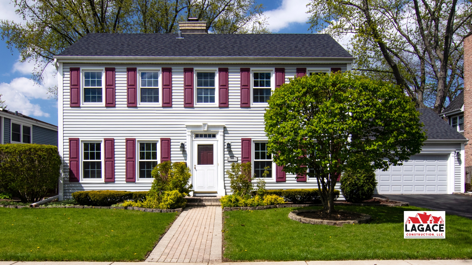 Classic Colonial-style home in Hebron, CT with white siding, red shutters, and a symmetrical two-story design, built by Lagace Construction.