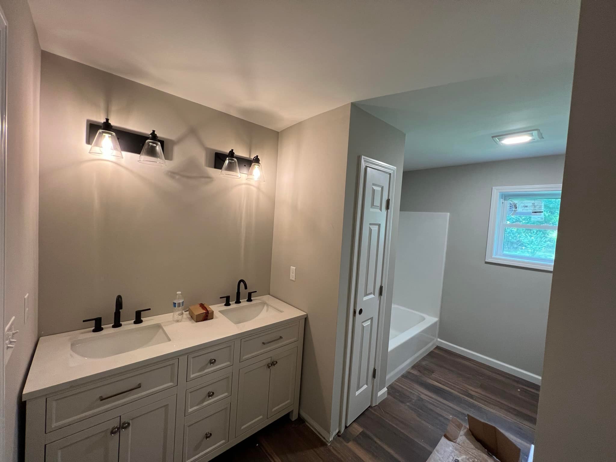Bathroom remodel in Tolland Bathroom remodel in Tolland County CT with double vanity, black fixtures, and new bathtub with modern lighting.