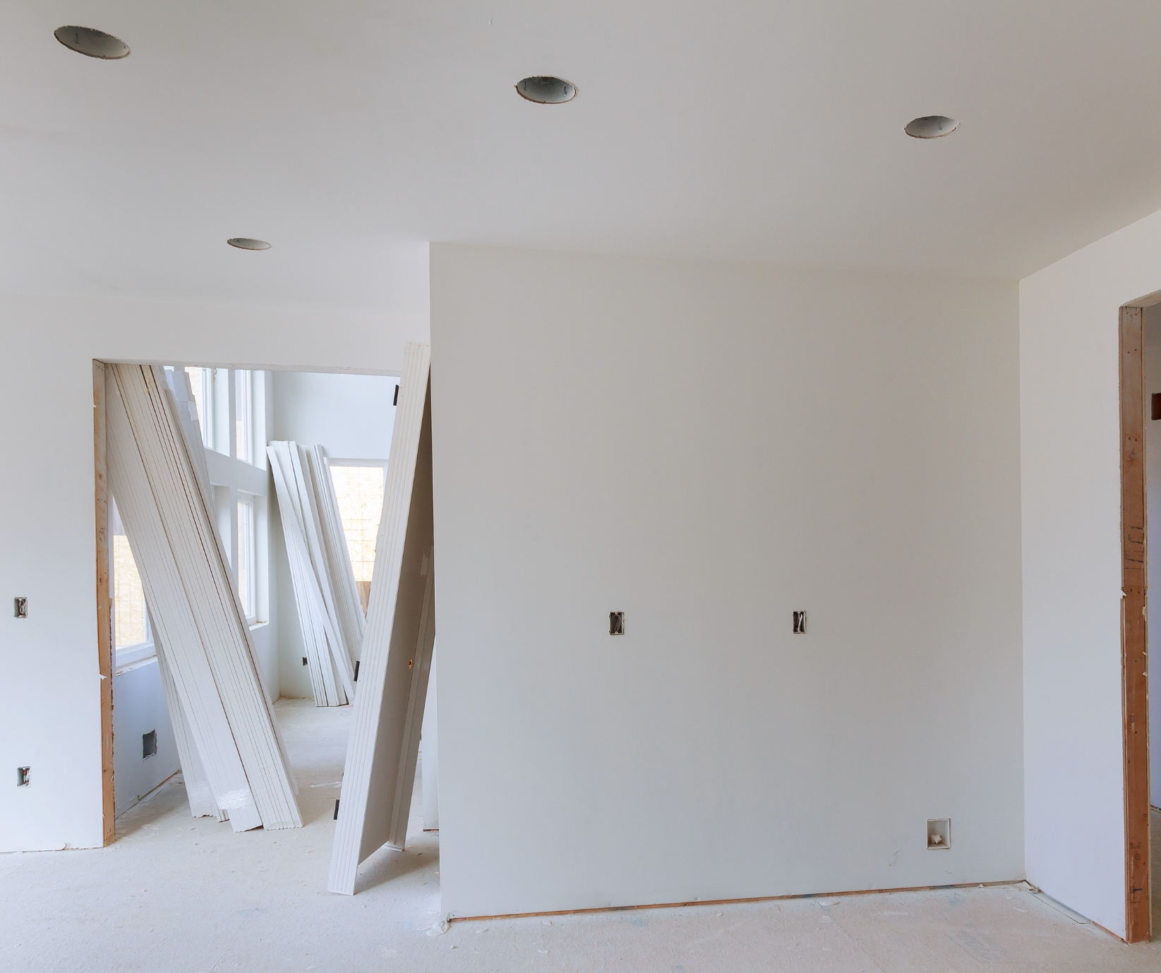 Before Basement finish in andover Basement renovation in progress in Tolland County CT with drywall installation, recessed lighting, and white primed doors.